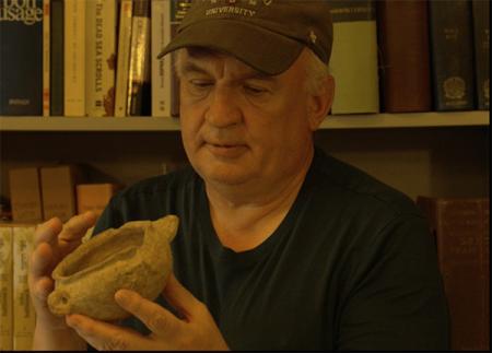 Father Eugen examines an archeological find at EBAF.